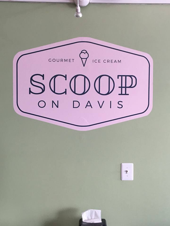 A green wall with a large, pink, hexagonal sign featuring the text 