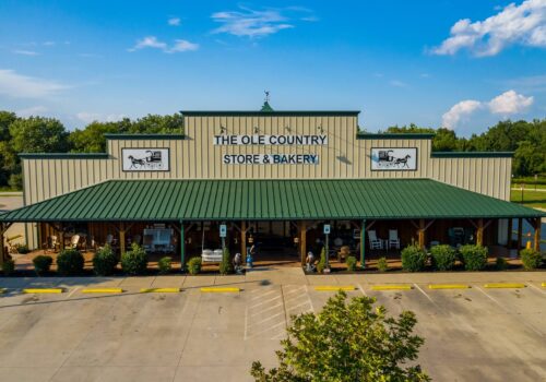 A large building with a green metal roof named 