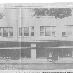 A black and white photograph of Lightfoot's Store in Draper, Virginia. The store is in a two-story building with a row of windows on the upper floor and large storefront windows on the ground floor. Various items are displayed in the store windows.