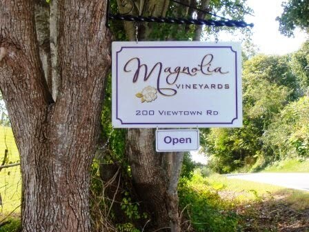 A sign hanging from a tree reads 