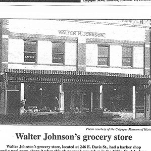Black and white photo of a building with a sign reading 