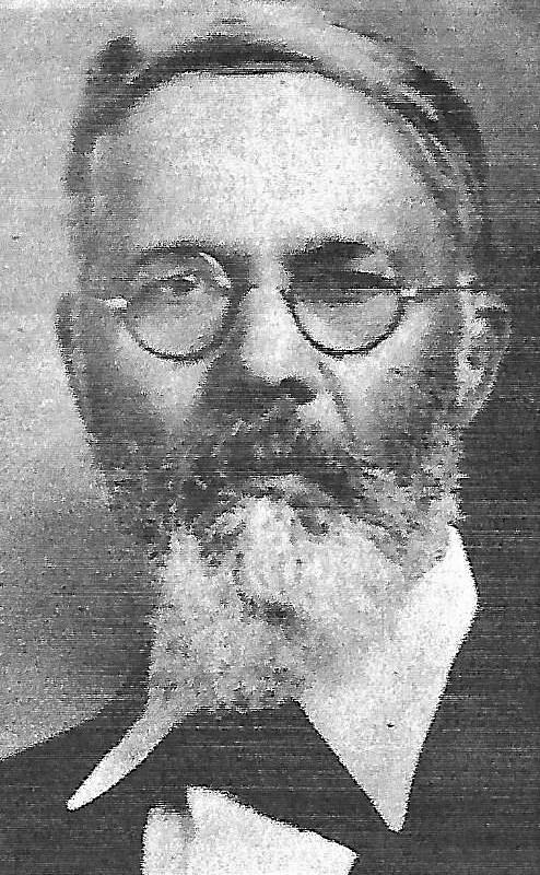 Black and white portrait of an older man with a full beard and mustache, wearing round glasses. He is dressed in formal attire, including a high-collared shirt and a coat. The image has a grainy texture, suggesting it is from an old photograph.