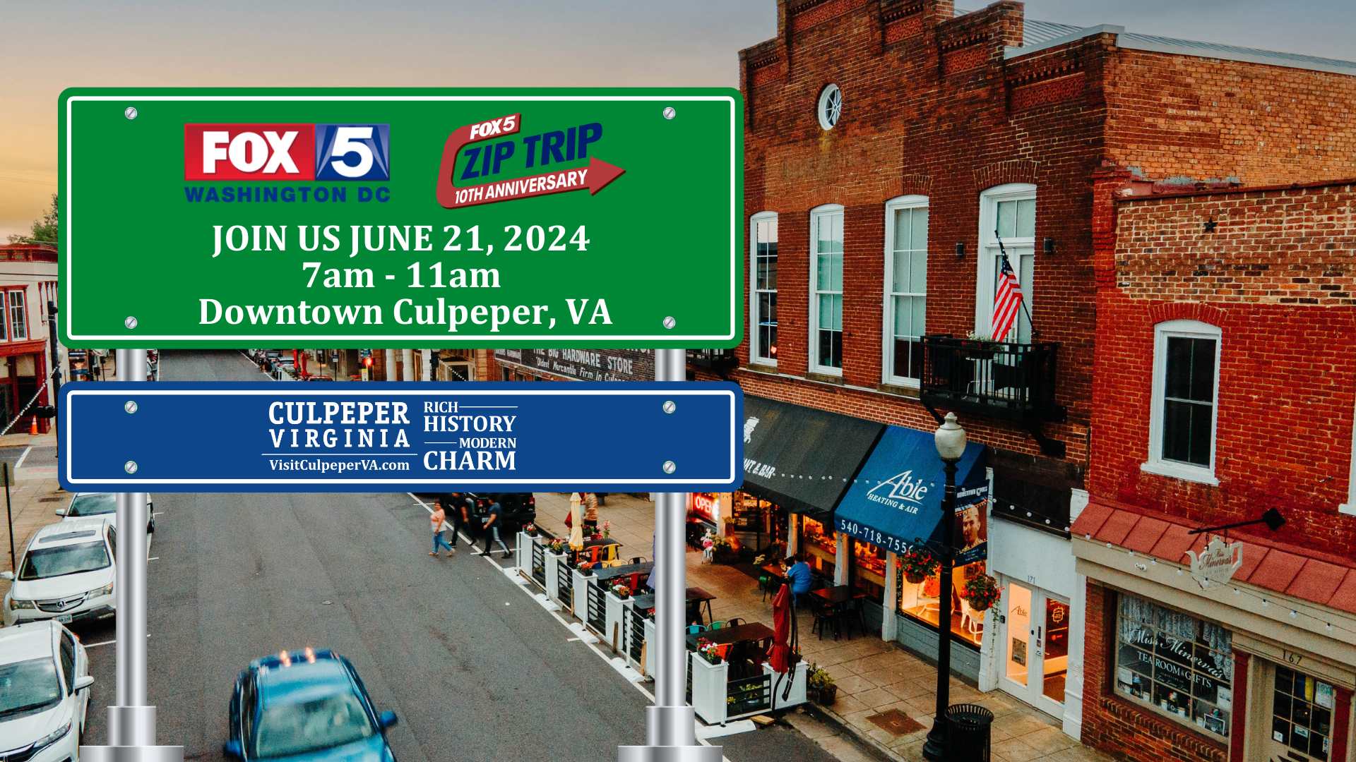 Street view of downtown Culpeper, VA, featuring a brick building with small businesses. Prominent street signs advertise Fox5DC Zip Trip's 10th Anniversary on June 21, 2024, from 7am-11am, highlighting the charm of visiting Culpeper, VA.