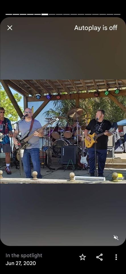 A band performs on an outdoor stage. Two musicians are in the foreground, one playing a bass guitar and the other playing an electric guitar. A drum set is visible in the background. Colorful stage lights are set up above them. The date reads June 27, 2020.