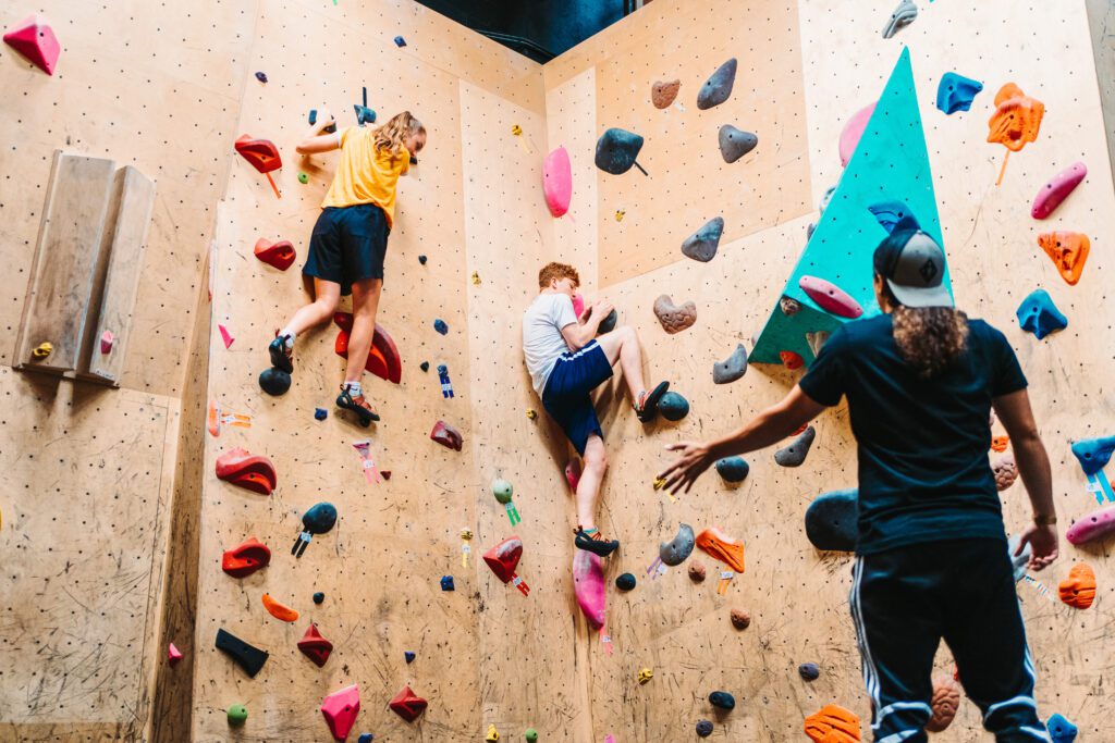 two kids climbing a rock wall