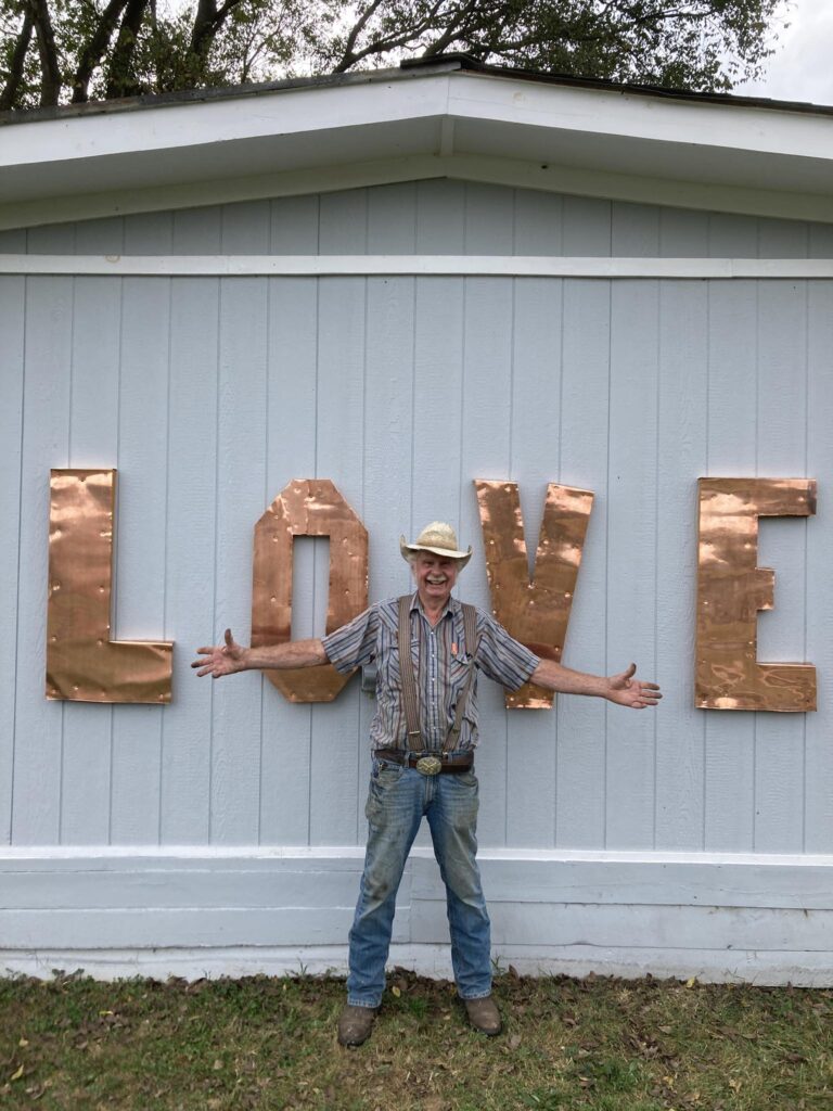 man standing in from of a LOVE sign
