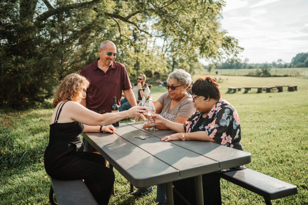 group of four people clinking glasses together in a "cheers."
