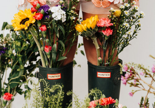 blooms coming out of a boots with a persons legs showing Image