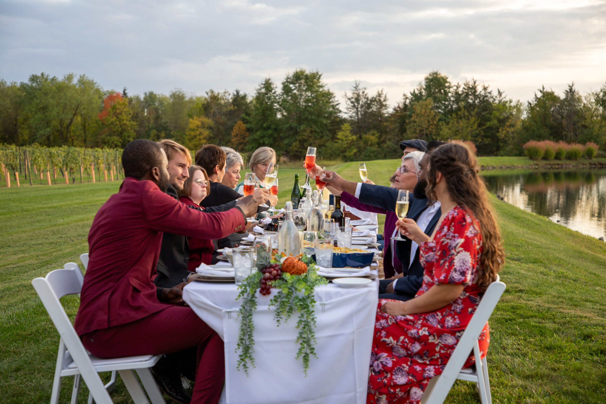 group of people dining at a table outdoors, in a field