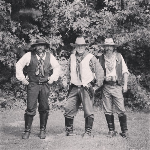 three men standing in western attire