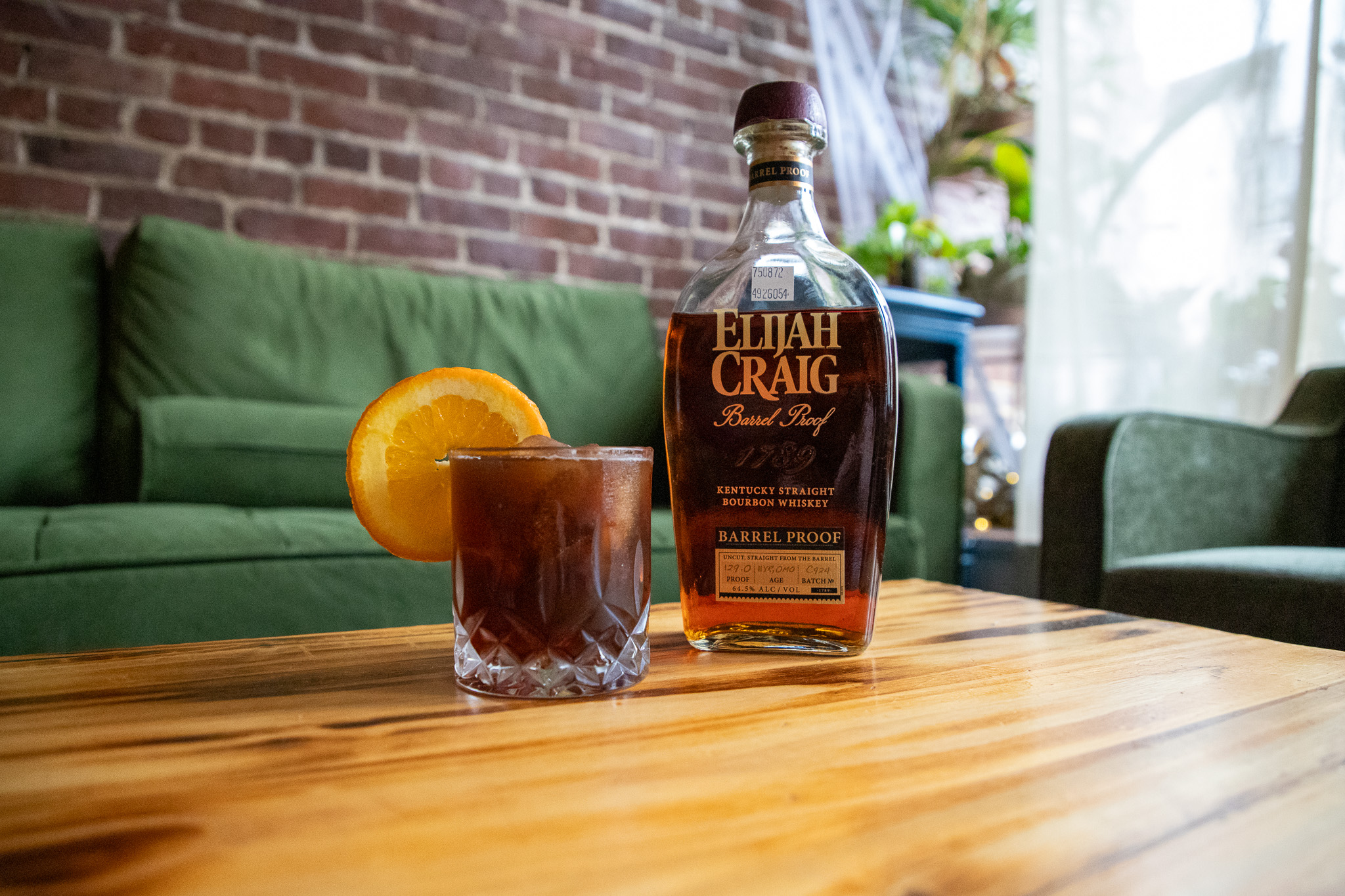 bottle of Elijah Craig and a brown drink with an orange